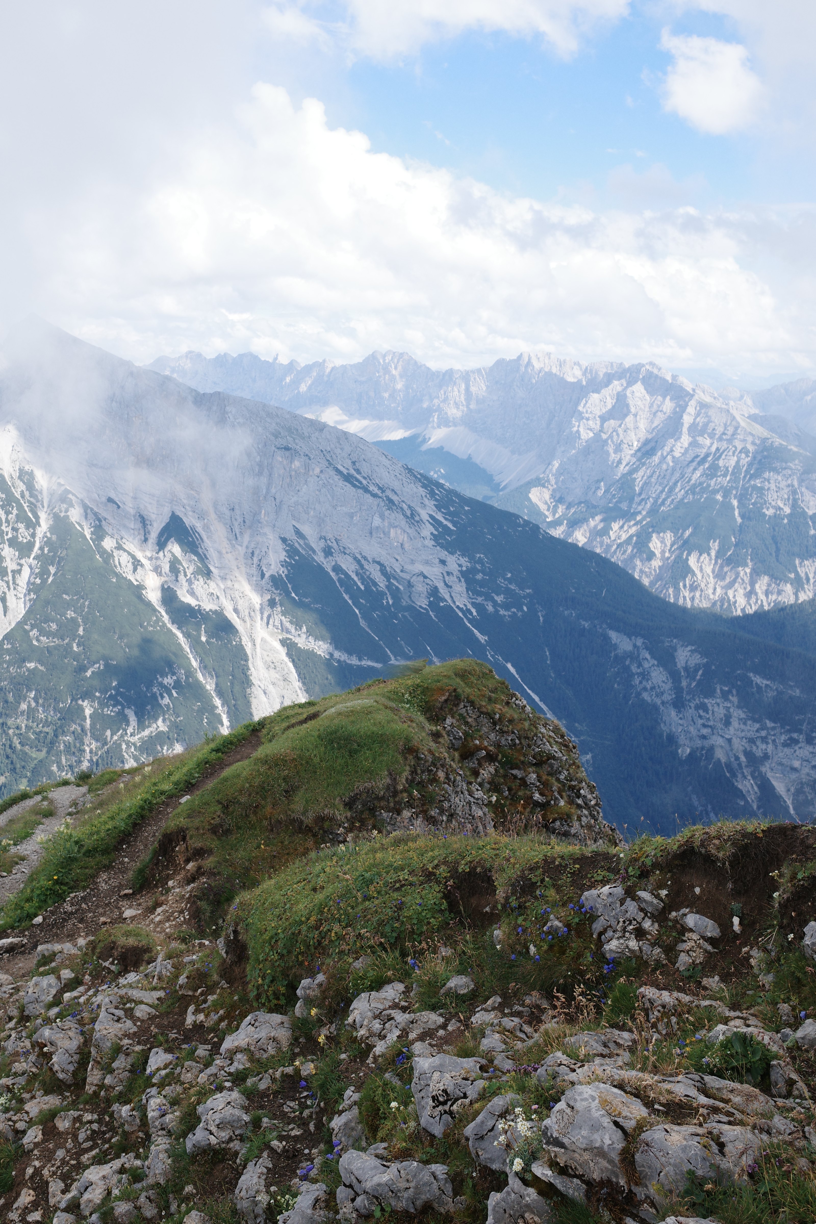 Liam Gergen standing on a rock ledge above the Karwendel range in the Alps